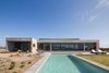 Modern home with Outdoor, Front Yard, Stone Fences, Wall, Concrete Patio, Porch, Deck, Concrete Fences, Wall, Horizontal Fences, Wall, Hardscapes, Large Patio, Porch, Deck, Concrete Pools, Tubs, Shower, Desert, Decking Patio, Porch, Deck, Large Pools, Tubs, Shower, and Landscape Lighting. The volume of the master bedroom and the glass terrace, that looks toward the pool and the Pacific Ocean. Photo of Pi House