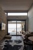 Modern home with Living Room, Wall Lighting, Sofa, End Tables, and Porcelain Tile Floor. The family room is part of the volume of the kitchen, dining room and living room, separated by the fireplace wall made of stone. Photo 10 of Pi House
