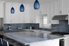 Modern home with Kitchen, Mosaic Tile Backsplashe, Drop In Sink, Recessed Lighting, White Cabinet, Range, Pendant Lighting, Wood Cabinet, Light Hardwood Floor, Range Hood, and Quartzite Counter. Kitchen Photo 2 of The Southold House