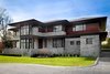 Modern home with Exterior, House Building Type, Hipped RoofLine, Wood Siding Material, Stone Siding Material, and Shingles Roof Material. Front Exterior Photo of The Manhasset House