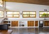 Modern home with Kitchen, Dishwasher, White Cabinet, Engineered Quartz Counter, Wall Lighting, Wood Cabinet, Undermount Sink, and Concrete Floor. All of the windows in the house were individually designed and hand built. The goal was incorporate a strong feeling of connection between the exterior and interior. Photo 2 of Casa Brumas
