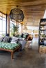 Modern home with Living Room, Gas Burning Fireplace, Chair, Bench, Sofa, Bookcase, Ceiling Lighting, and Concrete Floor. The living room light was hand built on site as a collaboration between a grandfather and grandson. Photo 7 of Casa Brumas