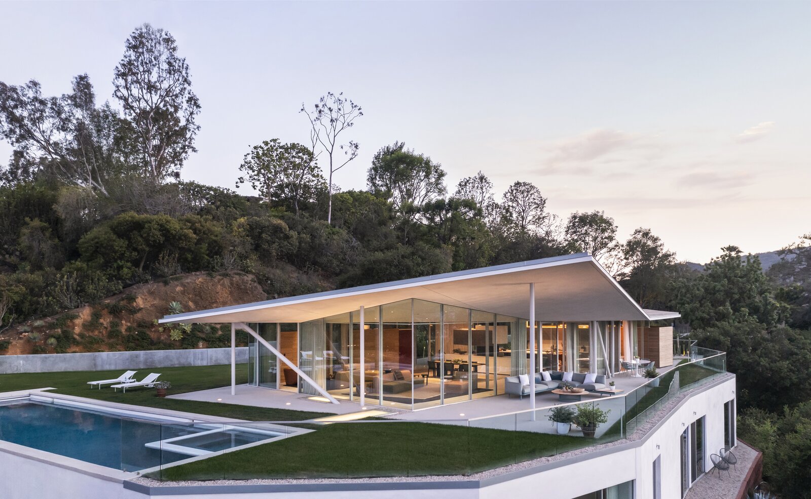 A one-foot-thick concrete retaining wall partially wraps the pool and garden area, which is set atop the lower level’s strong and flat roof.
