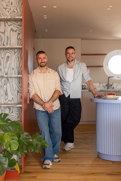 A portrait of homeowners Carlos García and Victor Gómez in their updated kitchen.