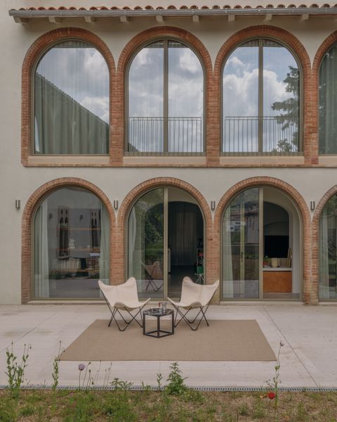 An extra arched window was added to both floors to create more symmetry and bring in more daylight. Work in the patio is on hold for the moment, though the owners envision plants that will adapt to the location's cold winter climate, a pond to attract birds and a garden that is truly lush - like you are living in nature.