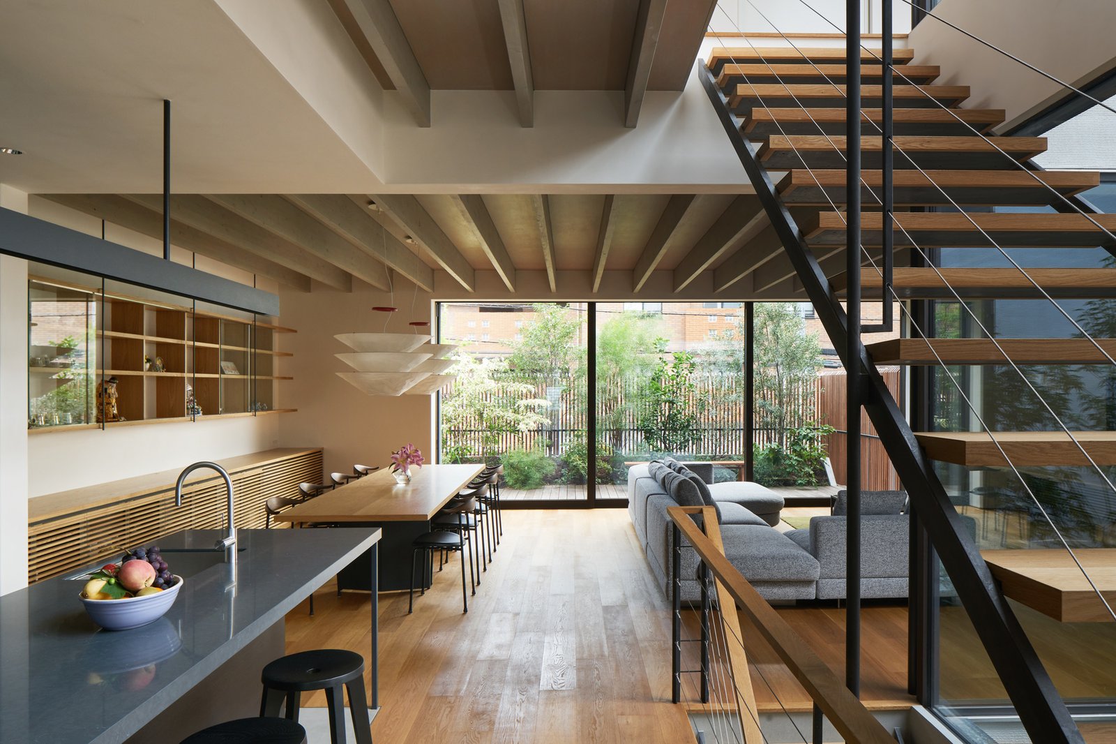 An Ingo Maurer Flotation light hangs over the Keiji Ashizawa-designed kitchen table, which is lined with Carl Hansen chairs.