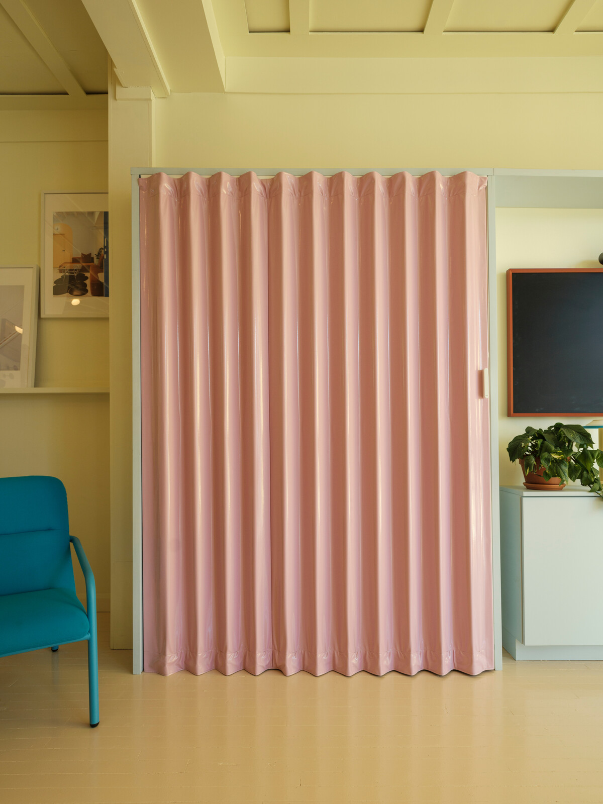 A basic storage closet is made into something special with this glossy pink folding door. 