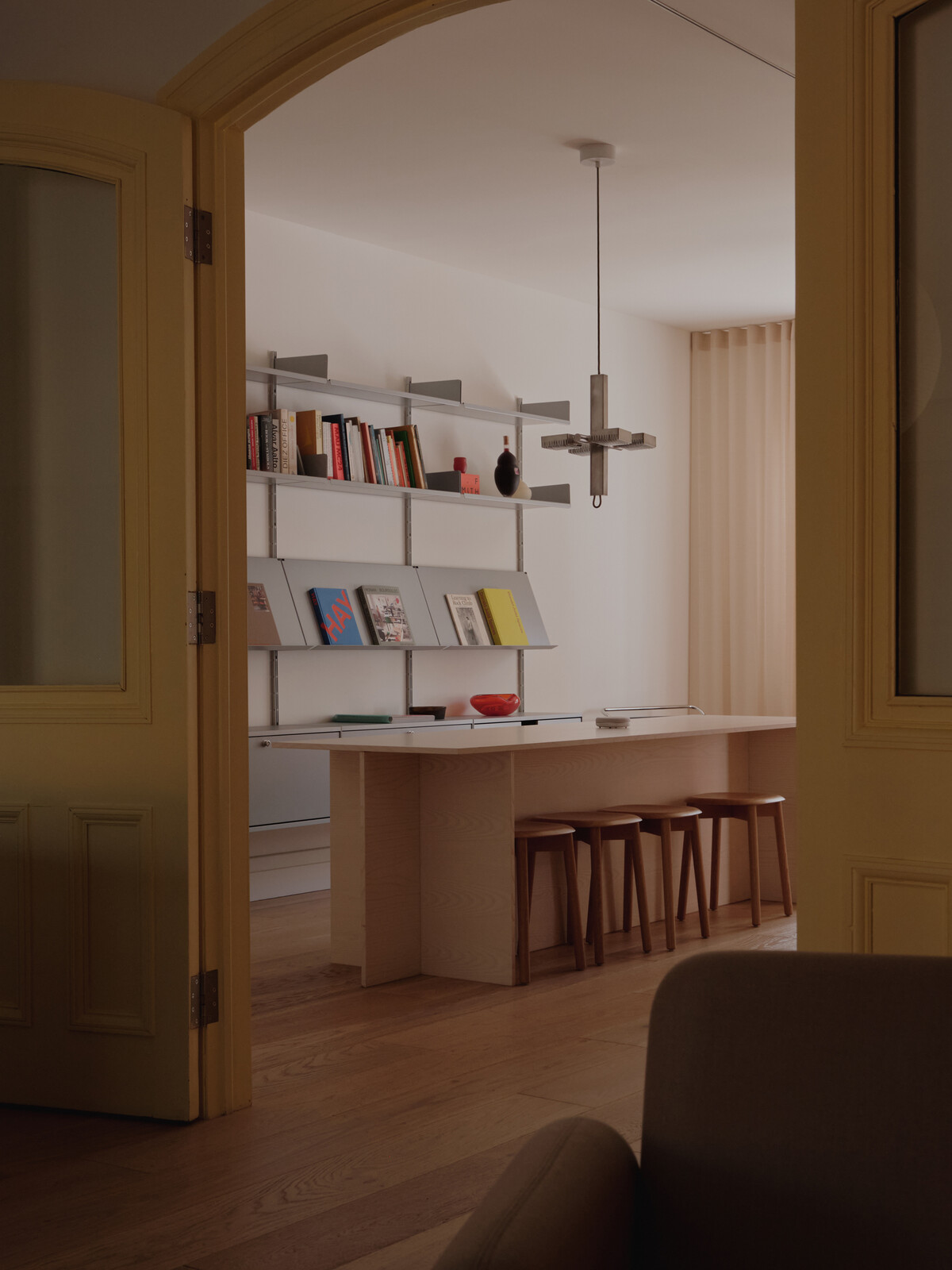The pendant light here is Lambert and Fils, a special piece from the company’s 15th anniversary sale. The Vitsoe 606 storage system displays inspiring books and reference materials. 