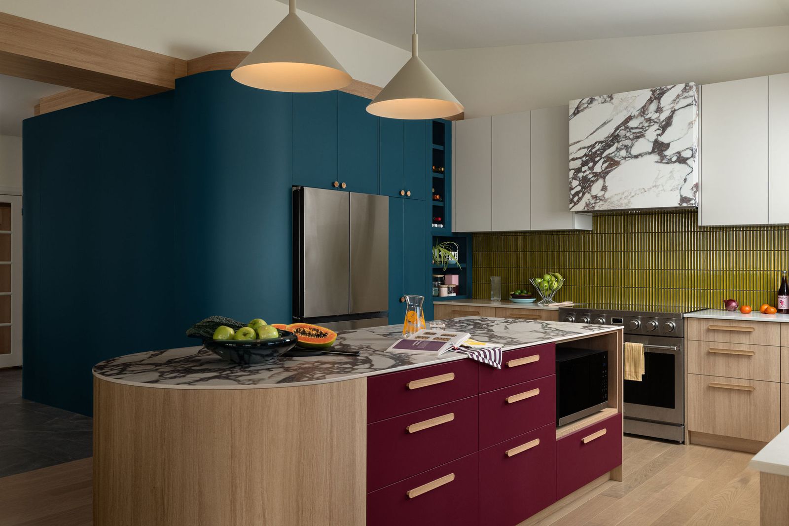 Calacatta Viola Laminam porcelain tops the island and wraps the vent hood. Article's Aino pendant lights illuminate the space.