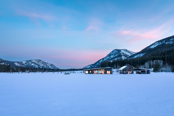 Three structures—the carport, the gear loft and the main house—string together across the five-acre property, their black metal cladding forming a cohesive architectural language.