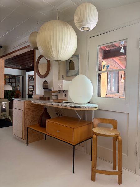 Not all cabinetry or shelving in a kitchen needs to be built-ins: a vintage coffee table fits neatly beneath the countertop to add a little extra storage.