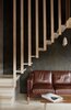 Modern home with Living Room, Sofa, Medium Hardwood Floor, and Wall Lighting. Interior with Stouby leather sofa, floating staircase and walnut wood coffee table, the wall lights were reclaimed from a 1960's swimming pool in Coventry, made by a Swedish company called Ifö. The ply wood walls have been painted with Osmo Oil in a hand mixed colour that we felt complimented the space, we liked the textural element of leaving the ply on show. Photo 5 of Hergest Lee