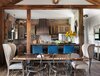 Modern home with Dining Room, Chair, Ceiling Lighting, Storage, Table, and Medium Hardwood Floor. The Dining/ Kitchen Area
Serving as the client’s personal hunting getaway and farm, this project demanded all the serenity of a peaceful natural retreat, combined with the rustic influence of the surrounding outdoors. Exposed beams and coordinating natural wood accents, including a gorgeous live edge walnut dining table, bring an authentic cabin feel to life throughout. Texture abounds, with details like deep blue distressed leather bar stools, a brick kitchen backsplash, cognac swivel lounge chairs, and weathered cabinetry adding boldness and visual interest. Photo 2 of The R Farm House