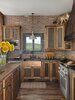 Modern home with Kitchen, Granite Counter, Wood Cabinet, Medium Hardwood Floor, Brick Backsplashe, Wood Counter, Drop In Sink, and Ceiling Lighting. The Kitchen
The home’s cabin-inspired feel carries into the kitchen with a blend of classic elements and modern features. The kitchen cabinets are made with century-old barn wood and feature corrugated tin insets. A hammered copper sink rests below a window framed in weathered barn wood, overlooking gorgeous views of landscape that lies just beyond. Stainless steel appliances and a butcher block island made of reclaimed barn wood complete the authentic feel of the space. Photo 3 of The R Farm House