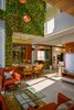 Modern home with Dining Room, Table, Recessed Lighting, Marble Floor, Wall Lighting, Pendant Lighting, Ceiling Lighting, Chair, and Floor Lighting. a stunning family sitting with a huge void space above connecting the ground floor to the highest ceiling of the house. With an artificial vertical garden in its backdrop, this space becomes even more appealing and colorful. This volume creates a drama of light and shadows throughout the day across the interiors with the triple-height window. Photo 4 of URBAN FRAME HOUSE