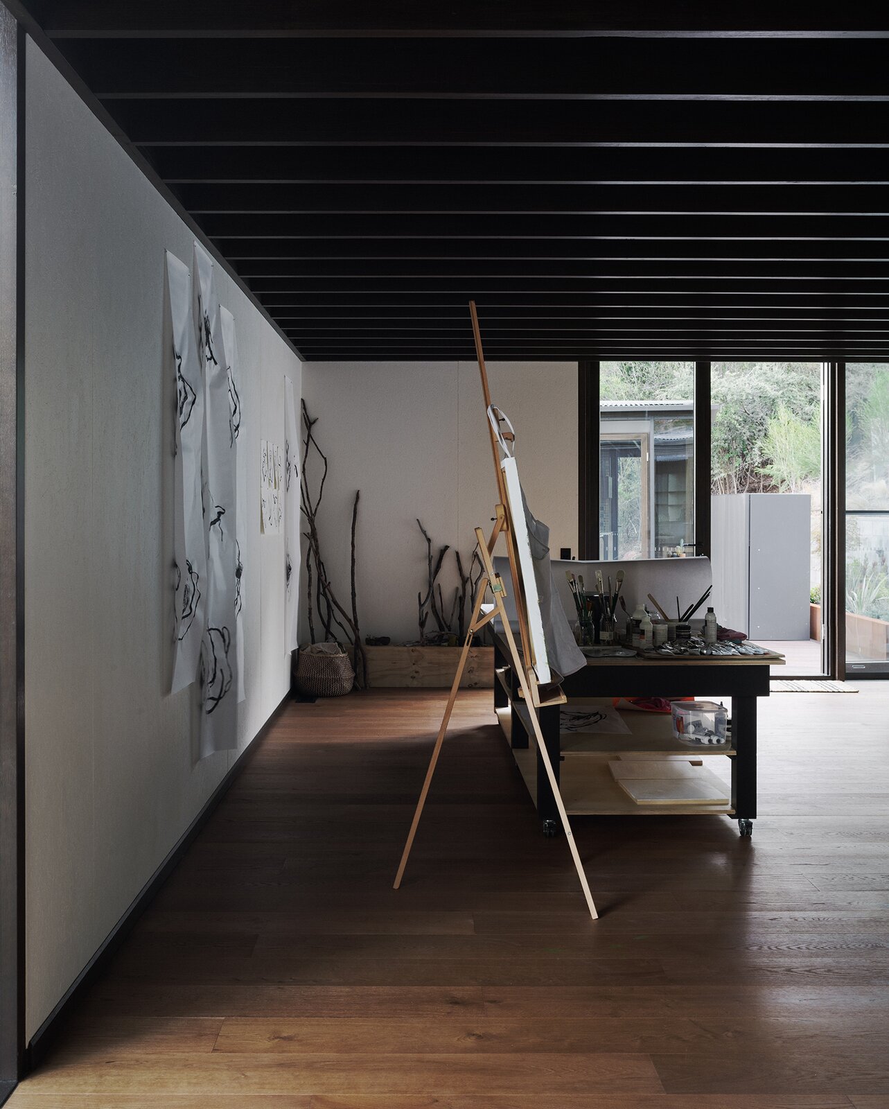 An art studio is separated from the main home by a deck.