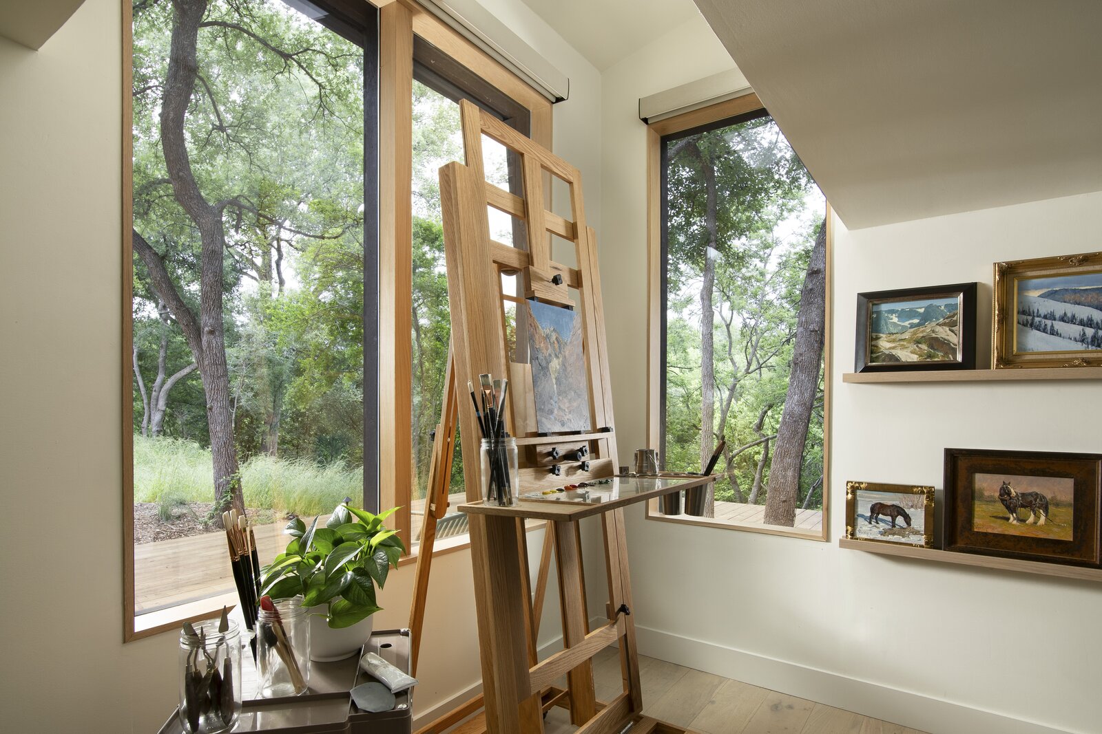 Generous windows, framed by electric shades, bring nature inside the space along with ample nature light for when inspiration strikes in the art studio. 
