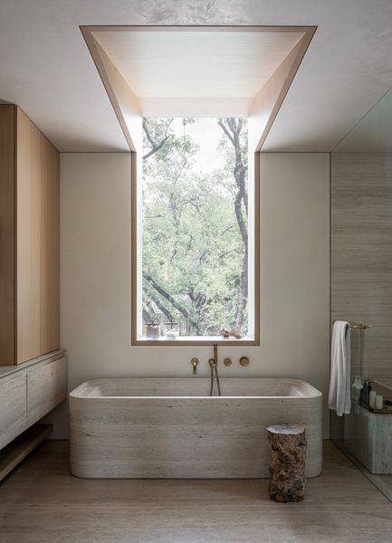 This 4,000-square-foot home is imagined as a quiet retreat tucked into a hillside. The lower level is carved into the natural slope, a gesture that blends the architecture into the landscape and preserves the surrounding canopy. The upper floor extends into the treetops, completing the luminous, calm environment akin to a modern terrarium—without sacrificing privacy.