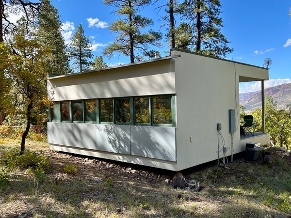 The windows and doors have hinged steel shutters, securing the cabin when the future owners are elsewhere.