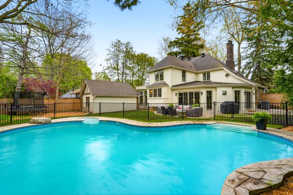 The fenced-in backyard has an in-ground pool and a stone patio.