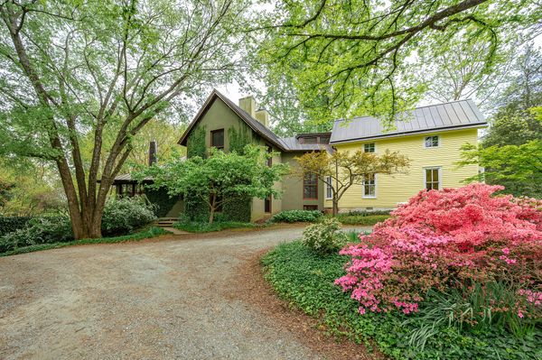 The lush yard is home to mature plantings, and historic oak trees and tulip poplars.