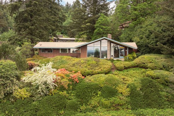 Nestled within a hillside lot, the home balances privacy and landscape views.