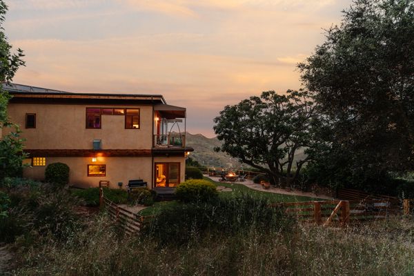 With nearly three acres of space, the house makes rooms for guest parking, an RV hookup, solar panels, a backup generator, and winding paths through fruit trees.