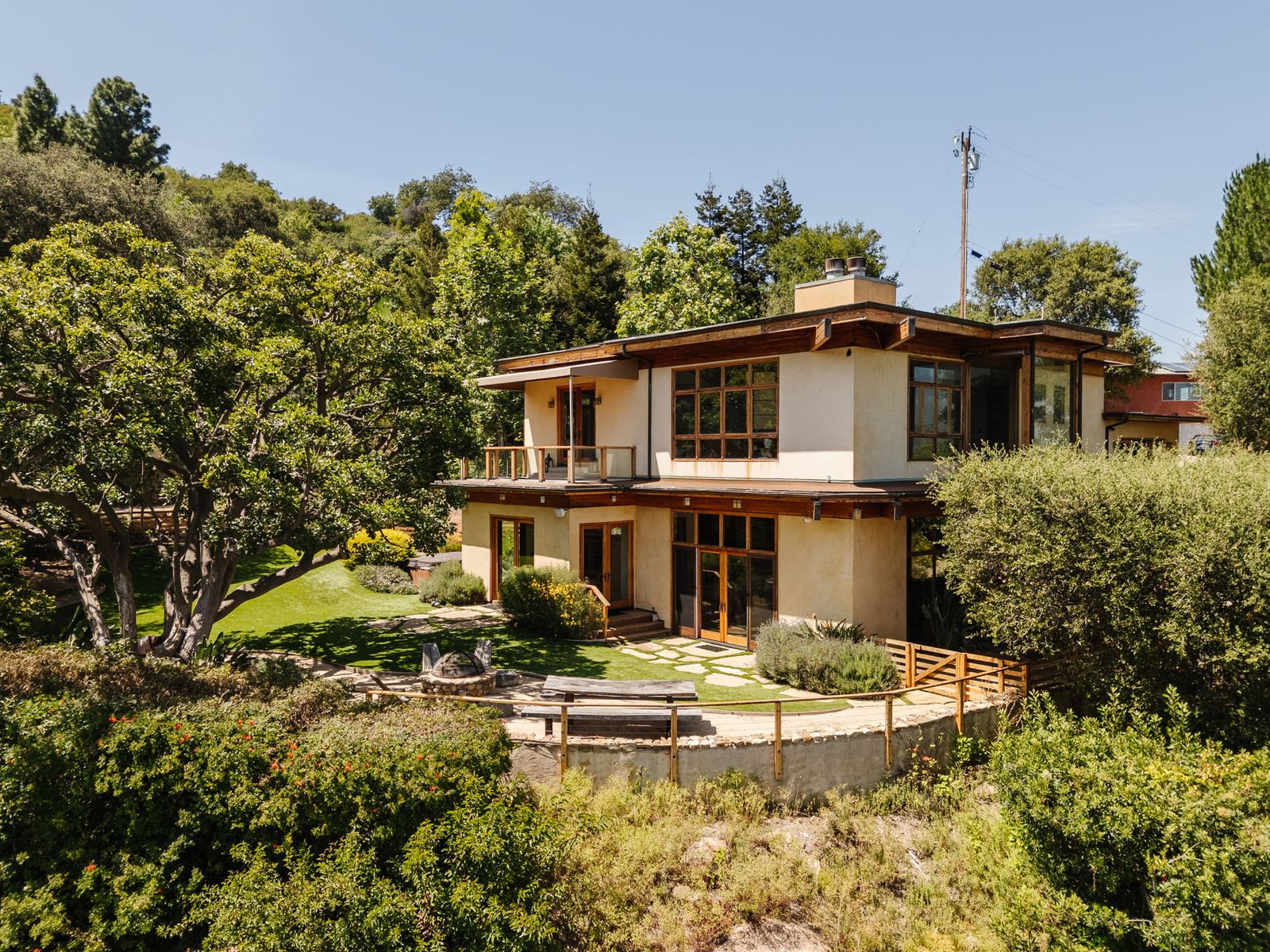 Surrounded by fruit trees, the 1979 residence has a multilevel living room, a secret speakeasy, and a glass-encased bathtub overlooking the landscape.