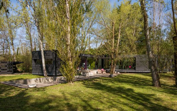 The sinuous 2012 residence is clad in standing-seam zinc and walls of glass that let you look right through it.