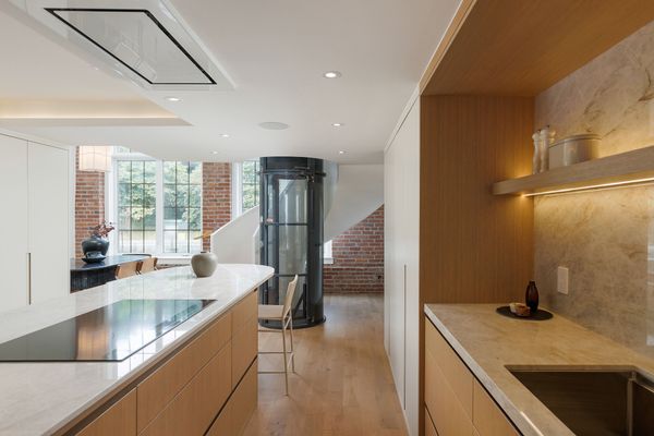The kitchen and dining room are lit by two-story windows.