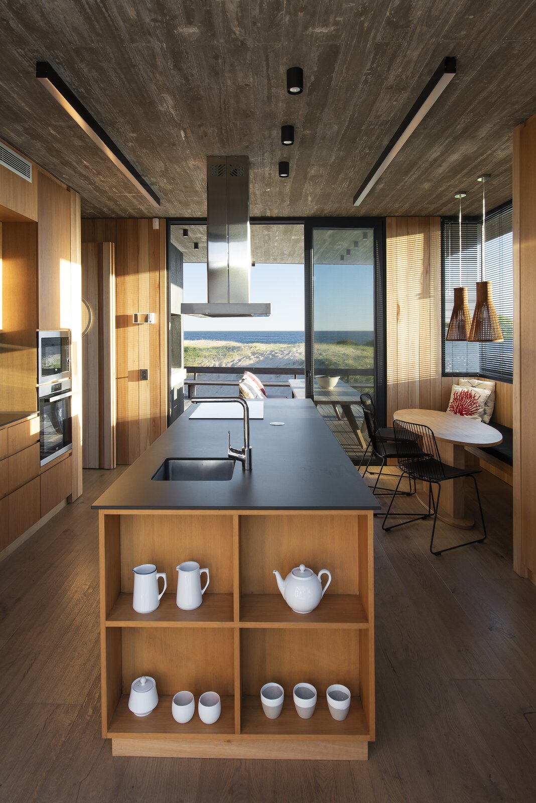 The streamlined kitchen almost feels like the galley of a boat. Open storage at each end of the island holds kitchen essentials, and a built-in eating nook is the perfect place for the kids, or guests, to sit and chat while a meal is prepared. 