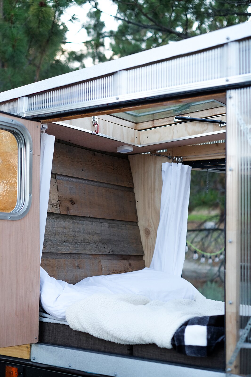 The wall behind the head of the bed is made with repurposed cedar that Douglas-Hui acquired at no cost.
