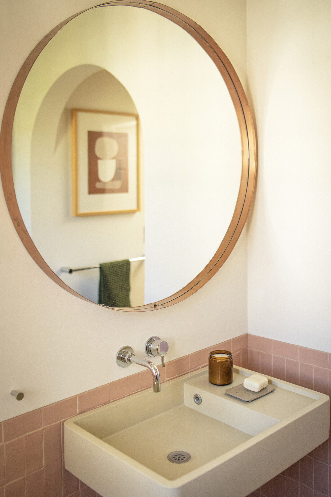 In the new guest bathroom, the Nood wall-mounted sink has a small, built-in countertop.  The blush pink tile is from File Tiles, and the fixtures are California Faucets.