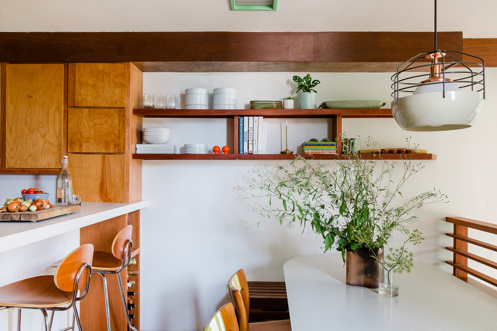 A pony wall was removed from one end of the dining room and replaced with a built-in bench and slatted-railing. The original casework used to extend across the length of the dining room, but Daniel and Sandy removed a strip and reconfigured it into stacked cabinets. 