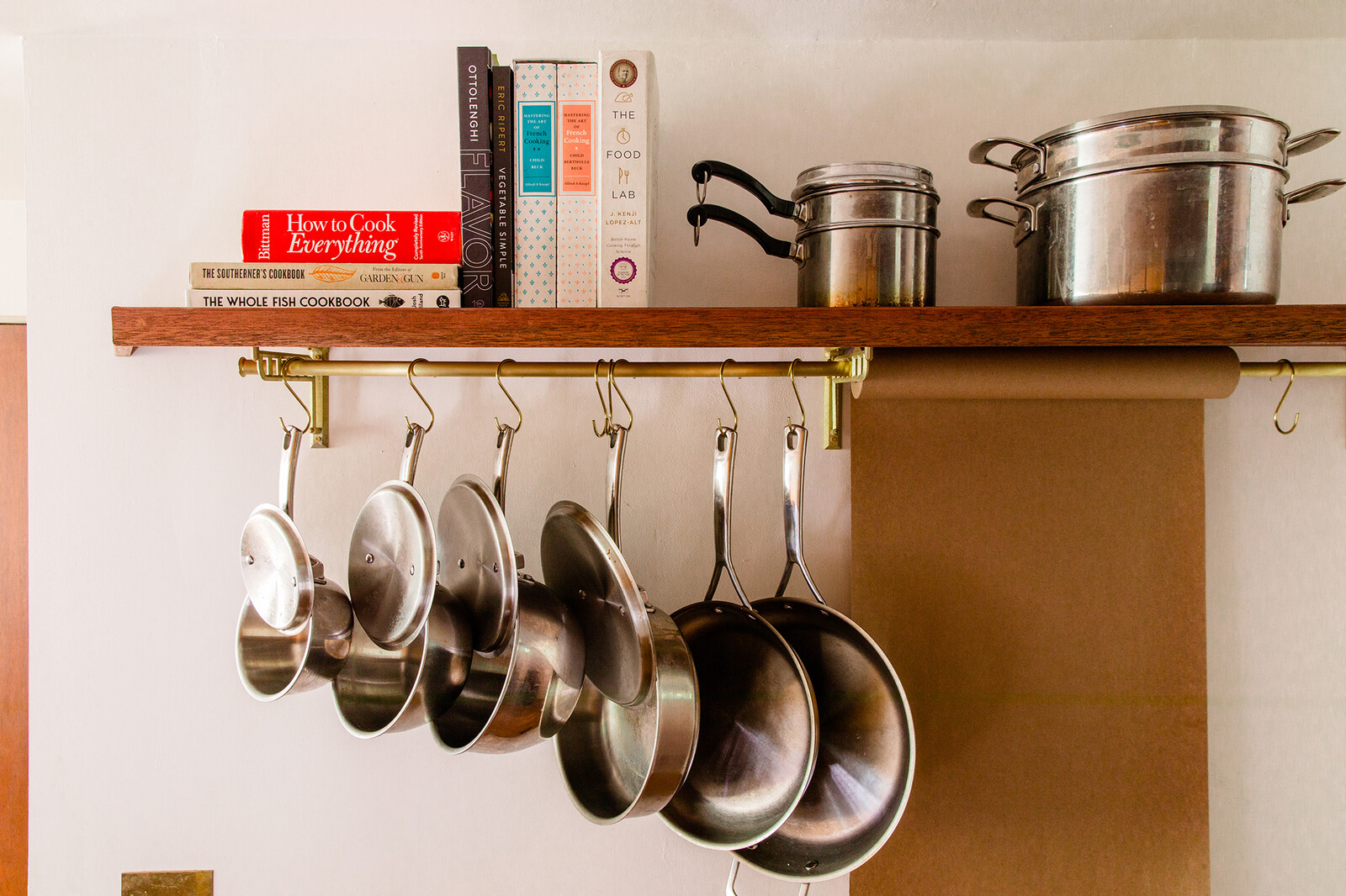 A custom shelf in the kitchen doubles as a pot rack, and a thoughtfully placed roll of butcher paper is a favorite drawing spot for the couple's young daughter. 