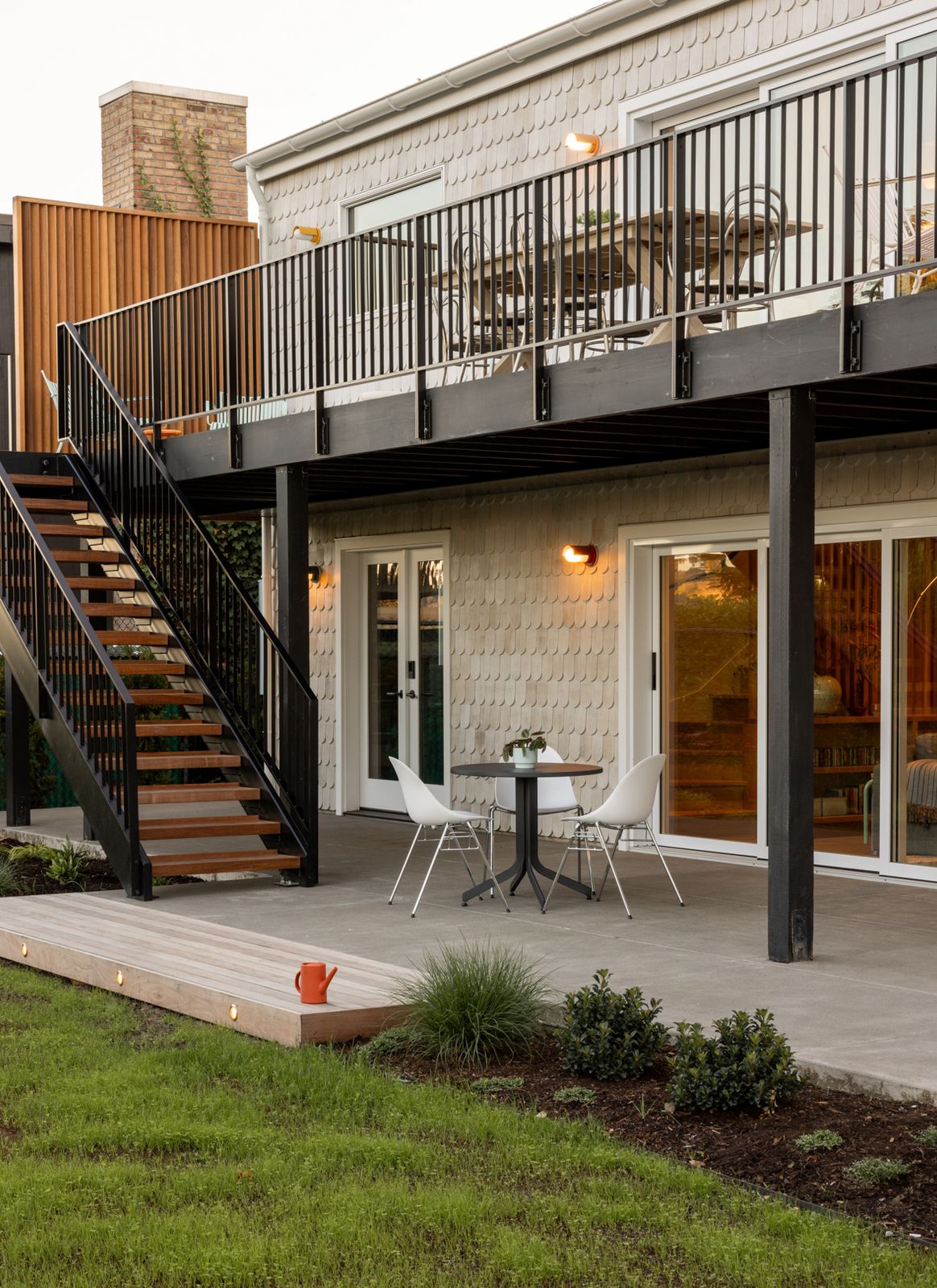 The architects retained the previous deck’s footprint but updated it with ipe boards. The sconces on both levels are the Bower model from Schoolhouse Electric. 