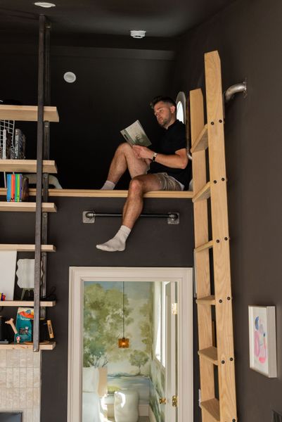 The loft, built over the bedroom, is accessible by ladder. In the main living area, Ben chose Pertola Paint's Training Wheels—an espresso-tinted blank tone—for the walls.