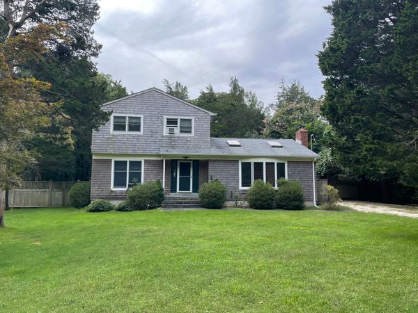Before: The home had a front bay window and minimal landscaping.