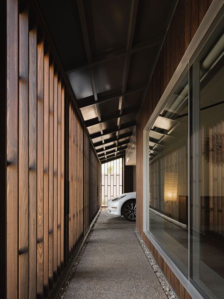 Deep overhangs and moveable brise-soleil across the home’s front facade reduce solar heat gain while also creating a protected circulation path outside the home’s walls. 