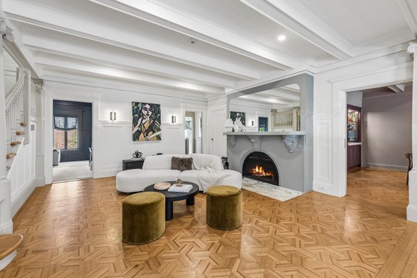 The living room is warmed by wood-burning fireplace framed with Calacatta marble.