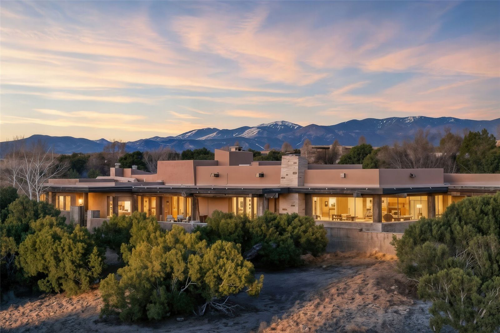 This sprawling, low-slung Santa Fe residence has plentiful patios, massive viga beams, and walls of glass that bring in high-desert views.