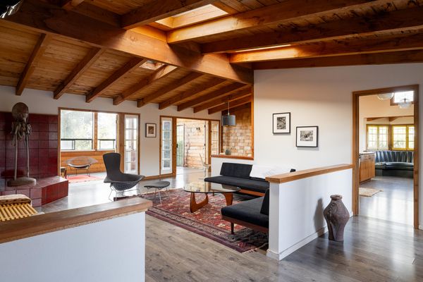 The exposed ceiling beams slope downward towards the home's edges, with skylights at the apogee.