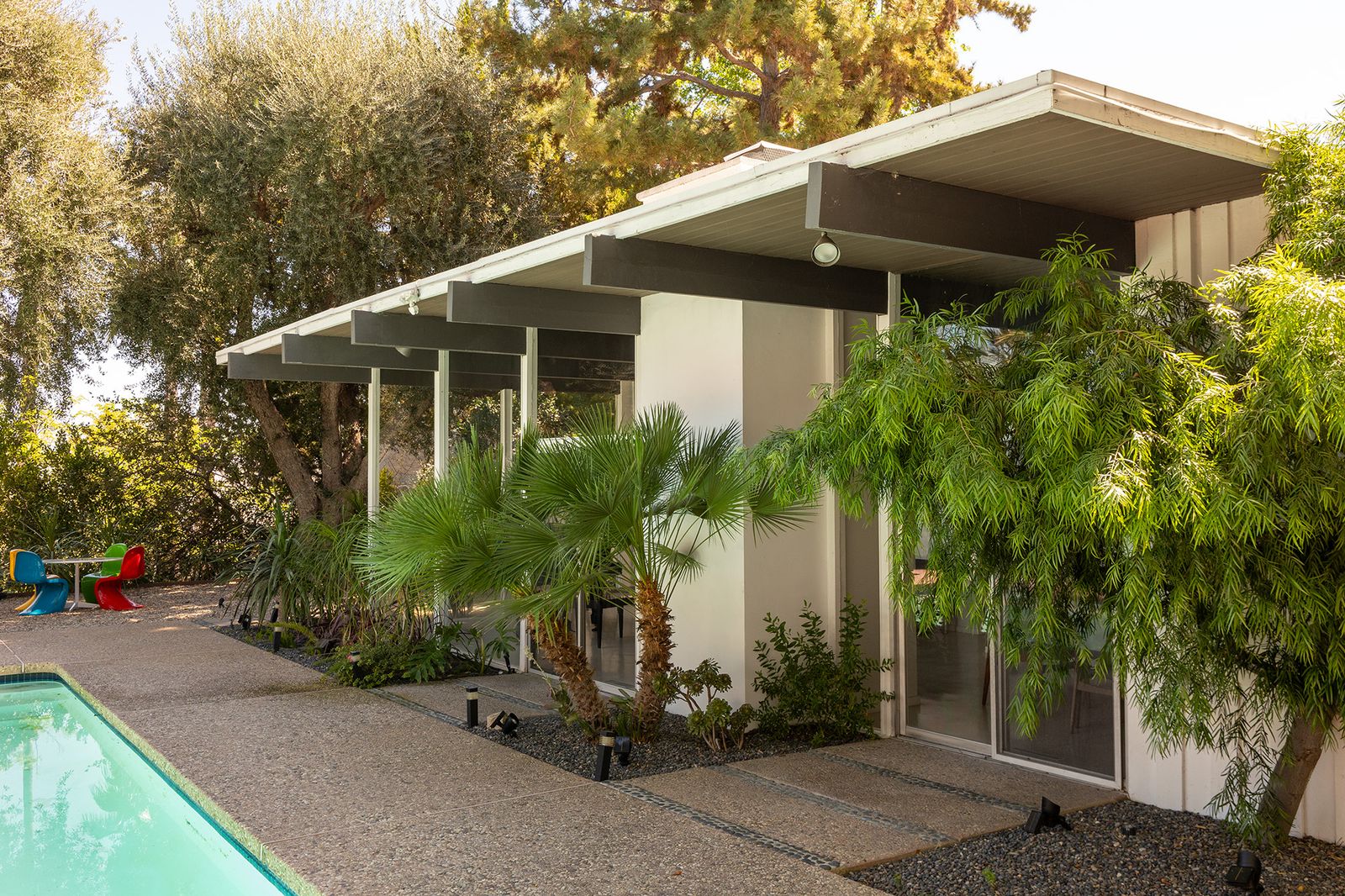 Designed by A. Quincy Jones and Frederick Emmons, the Harlan Lee House has floor-to-ceiling windows, mountain views, an interior courtyard, and a lush pool area.