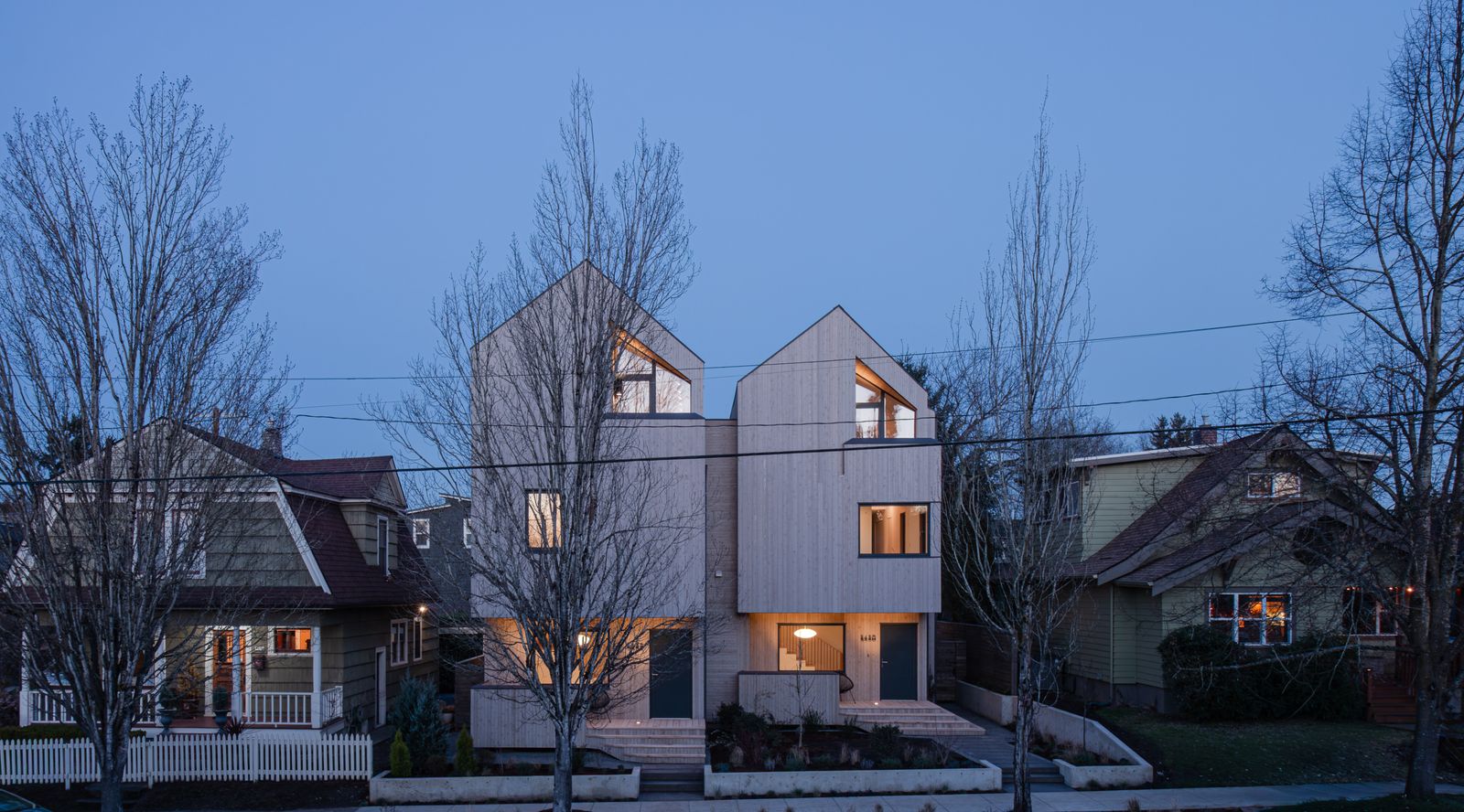 Mark Holmquist of Adret Architecture designed a pair of homes in Portland, Oregon’s Alberta Arts District with floating staircases, covered balconies, and nearly net-zero performance.