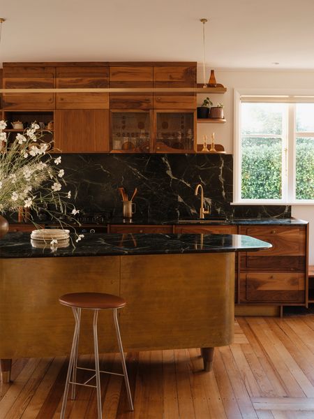 After: Solid walnut cabinetry sits comfortably beside the home’s original matai floors, reconnecting the kitchen to the house’s 1940s character.