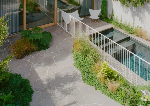 The pool bridges the two buildings. New sliding doors open the main house onto the water, and the studio faces it across the garden. "It has almost turned into a water feature in the backyard," Anna says.