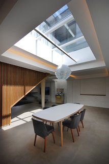 In the dining room of this London residence, a James Burleigh table sits beneath a sizeable skylight. Throughout the ground floor, additional lighting is recessed in the coffered ceilings. Painted brick walls provide a reminder of the building’s industrial past.