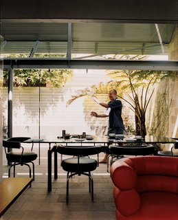 David Underwood, Langston-Jones’s partner, opens the large glass doors that expand the interior of the small house out onto the sun-drenched courtyard garden. In keeping with Langston-Jones’s love of Le Corbusier, the dining room chairs are LC7s and the table is an LC6 by the famed Swiss architect and Charlotte Perriand.