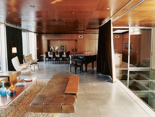 In the humidor-like living room, modern classics like the off-white armchairs by Hans Wegner complement pieces of Segal’s own design, such as the coffee table and long leather seating.