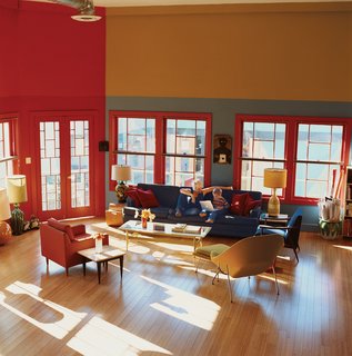 Sunlight streams through formerly boarded-up windows in the living area that was once Madame Wong’s stage. "When we took off the drywall, we realized there were windows in there. So we had more made to match these four," says Dan. The new windows open up the east side of the building to views of the courtyard below and the San Gabriel mountains in the distance. The apartment is furnished with an eclectic mix of furniture, including an Eero Saarinen womb chair.
